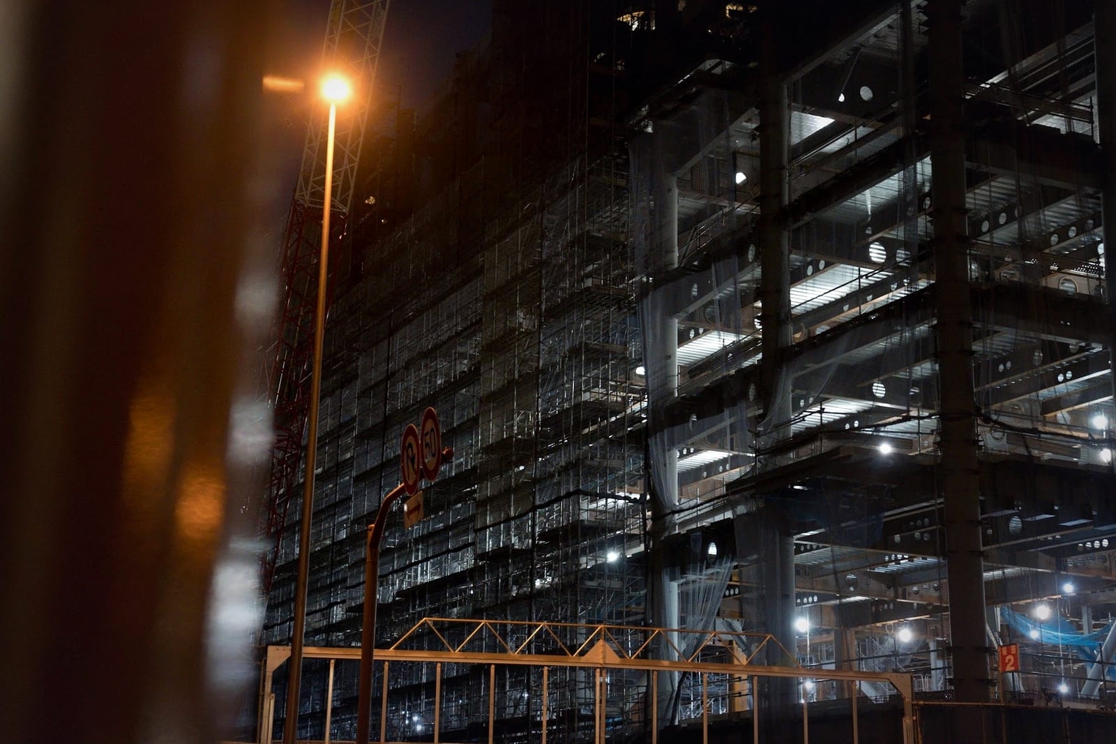 An industrial building at night, its interior floors lit and working while the exterior stays dark and empty